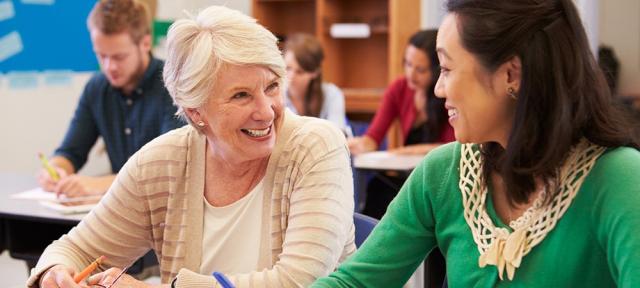 Older student smiling in class with younger students