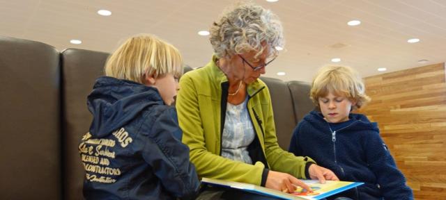 Older woman reading to two children