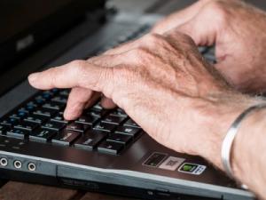 Hands typing on a laptop computer